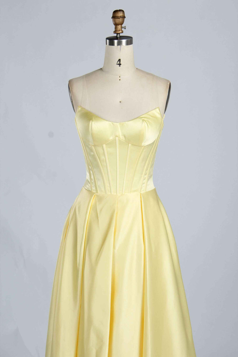 Close-up of light yellow Jessica Stuart Darcet Prom Gown bodice with structured boning and smooth satin finish.