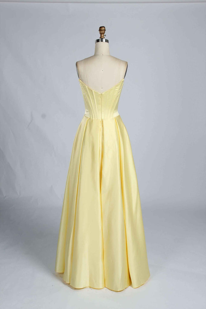 Back view of light yellow Jessica Stuart Darcet Prom Gown with V-back corset and flowing satin skirt.
