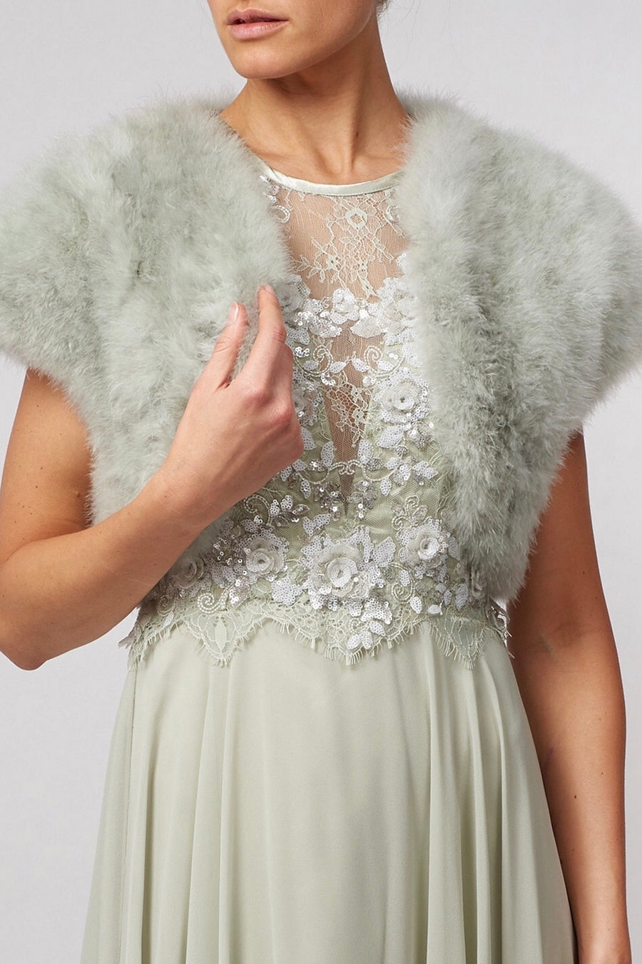 Sage green Feather Shrug FK042 by Mascara London styled with a lace embroidered dress, ideal for wedding guests or garden parties.