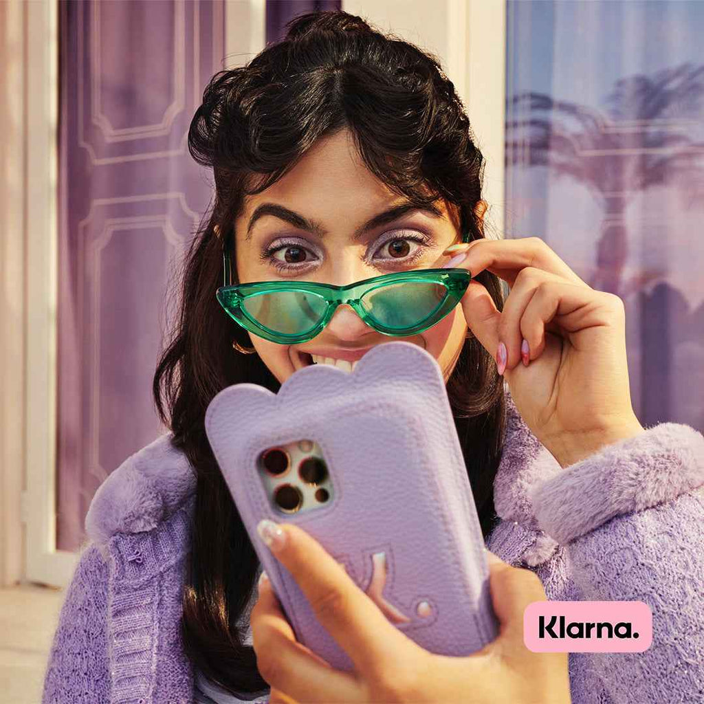 A woman smiling while watches something on her phone