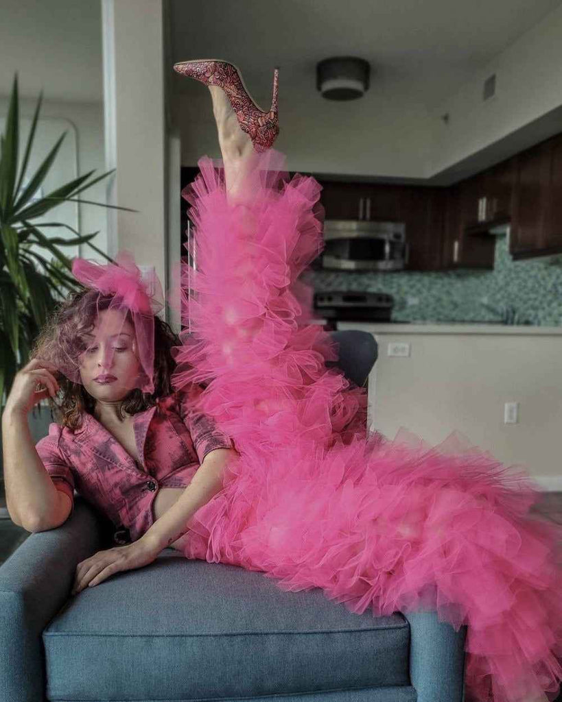 picture of a girl in a pink ruffle trousers posing on a chair