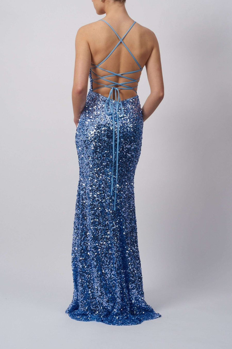 Powder blue sequin dress with tie back detail and crisscross straps, full-length design ideal for prom or red carpet events.