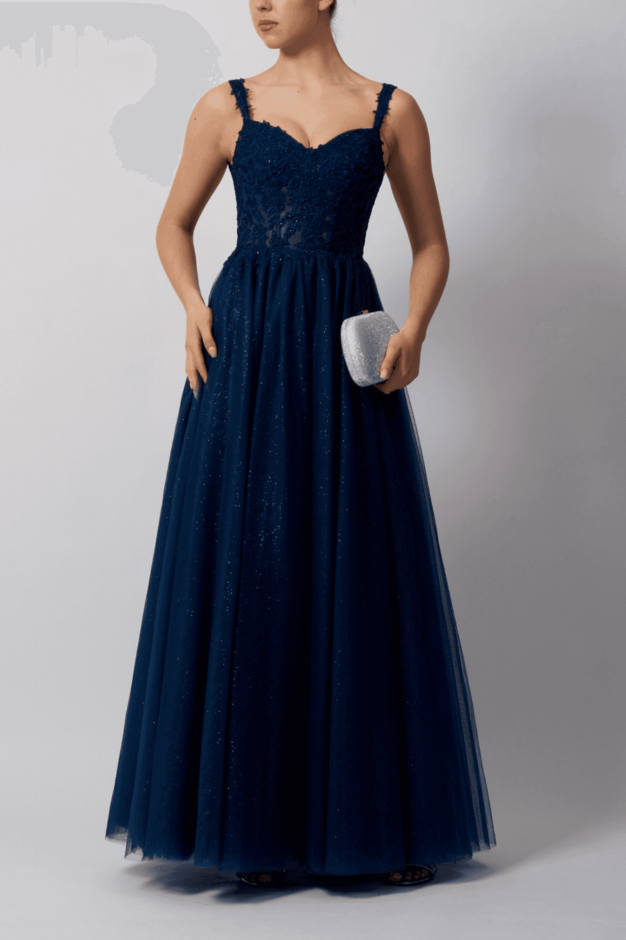 Mascara Navy Tulle Gown with floral embellishments and glitter details, perfect for prom or formal events. Features a fitted bodice and flowing skirt.