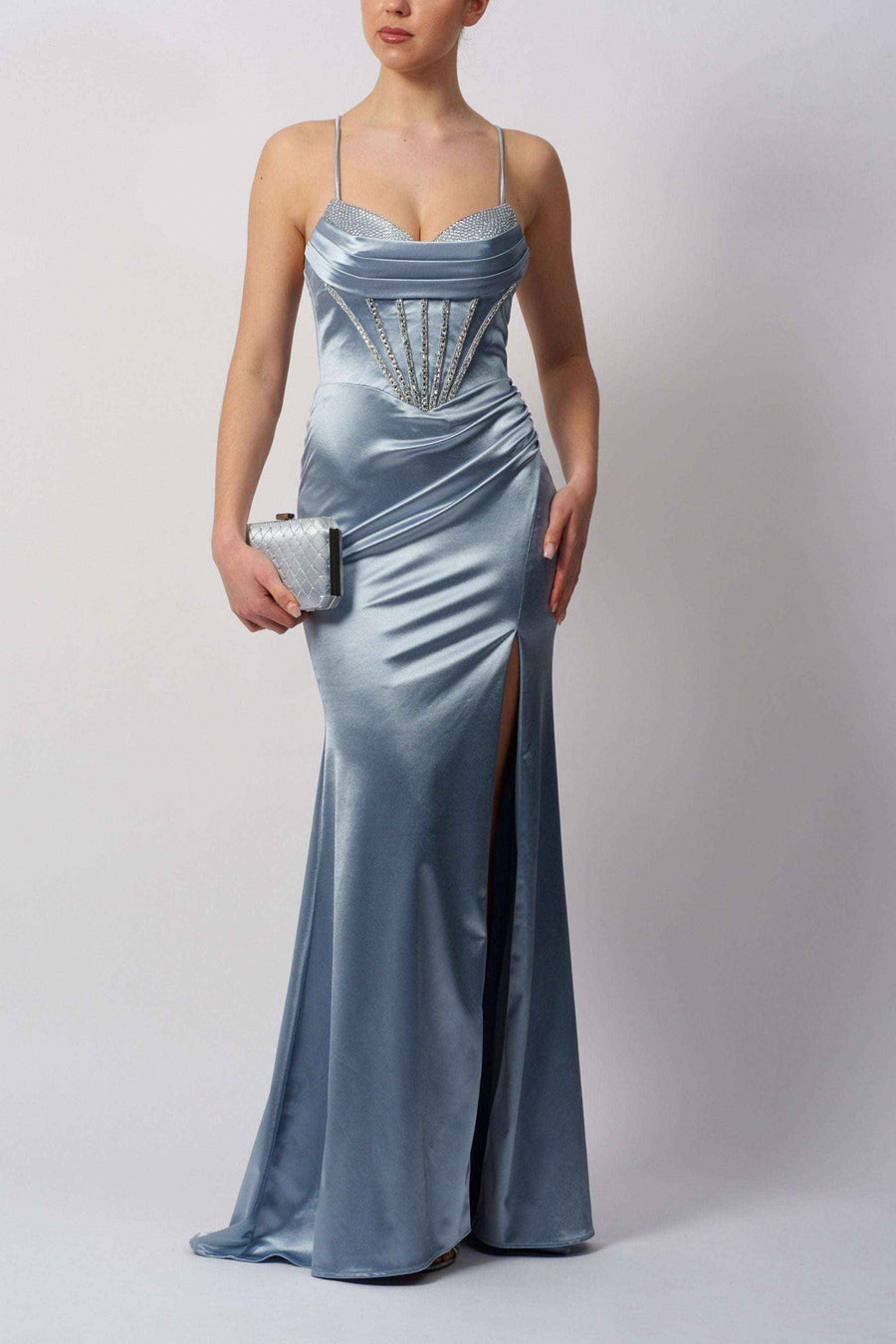 Shiny Steele Blue Jersey Gown featuring a thigh-high slit, ruched waist, and crystal-detailed bodice. Ideal for bridesmaids or special occasions.