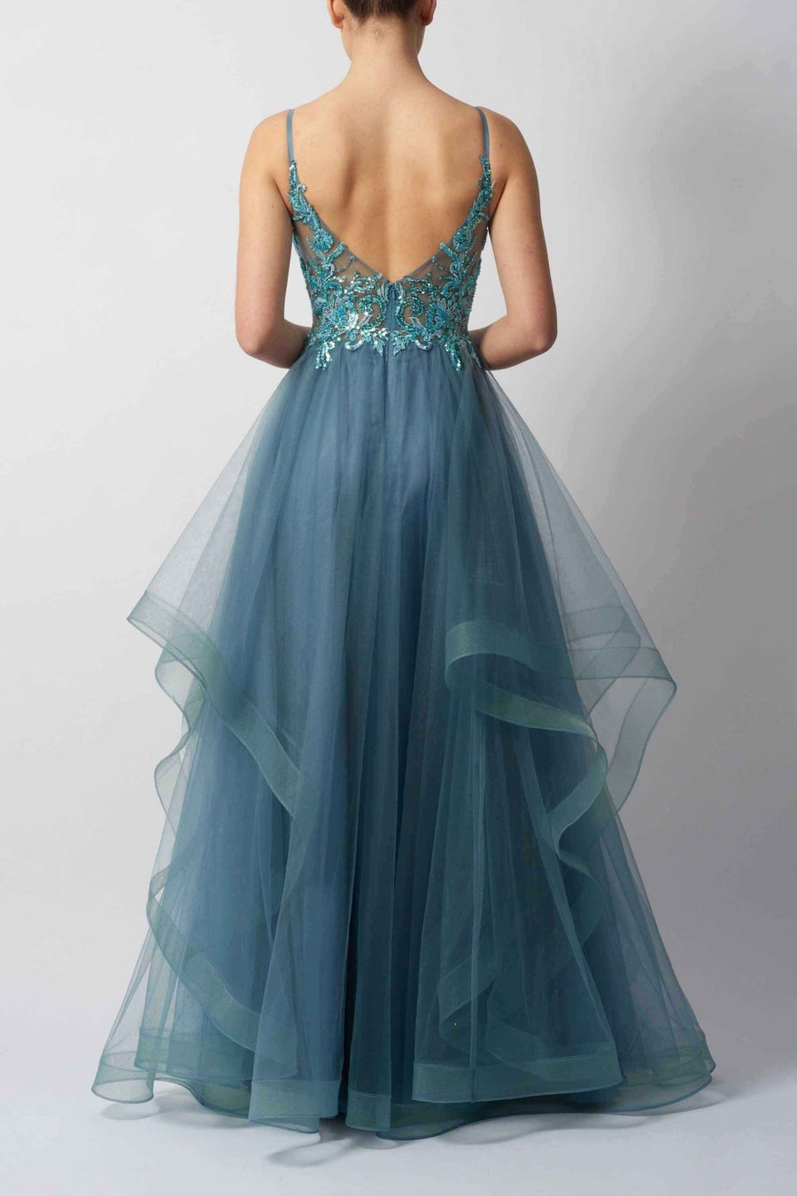 Back view of navy tulle ball gown prom dress with deep V-back, floral embellishments, and cascading layered skirt for red carpet-ready elegance.