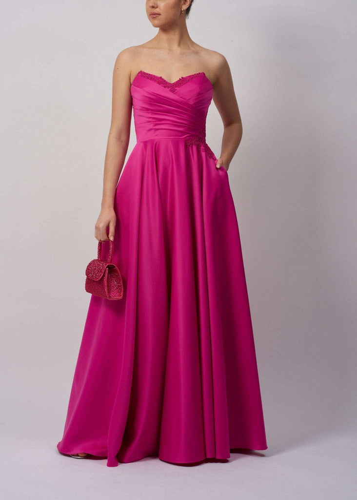 Mascara London MC124112 Navy Strapless Satin Ballgown in vibrant pink with sweetheart neckline, ruched bodice, and full-length skirt with pockets.