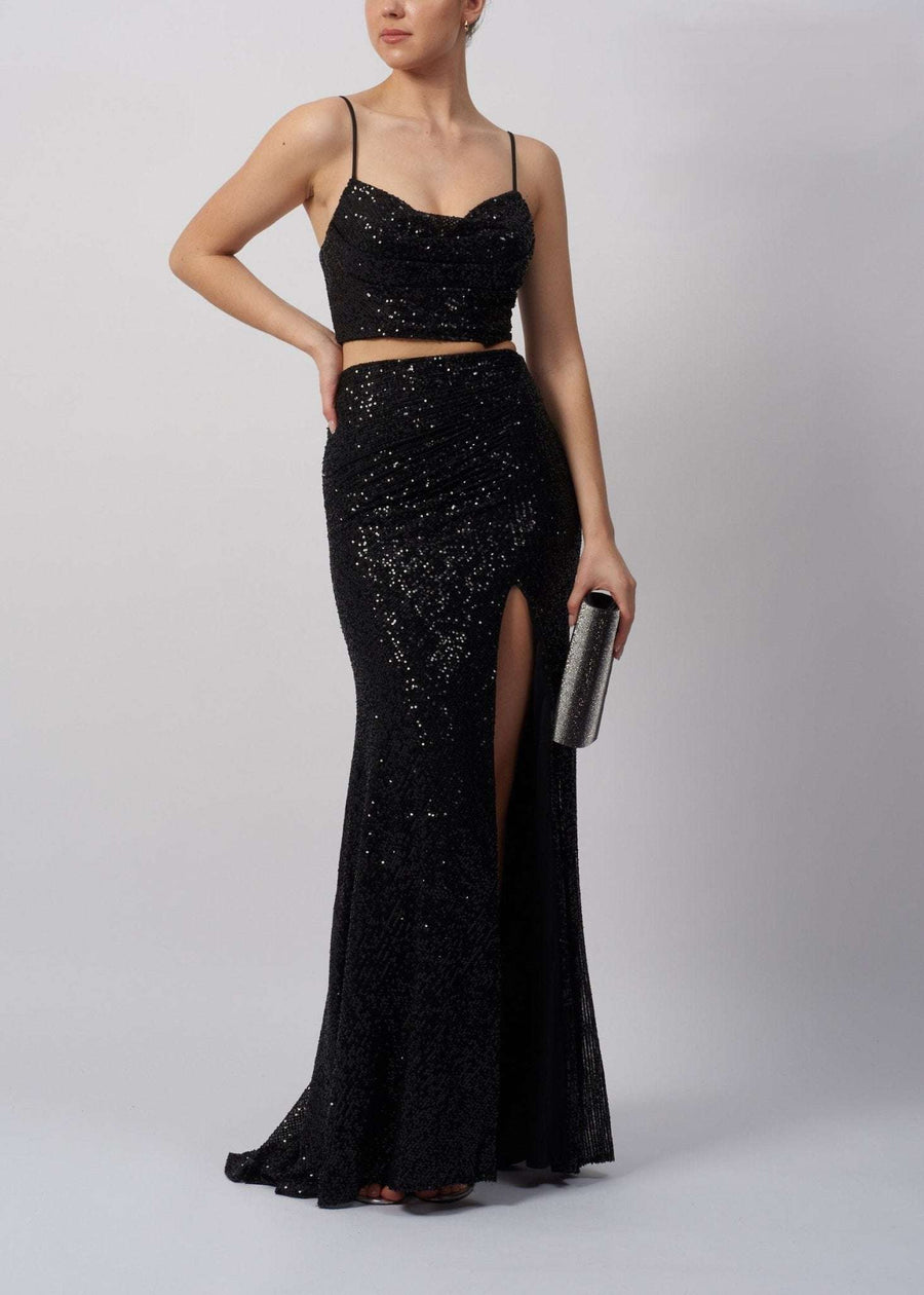 Mascara MC18326 Twin Set in black sequin features a fitted crop top with spaghetti straps and a high-slit maxi skirt. Perfect for prom or red carpet events.