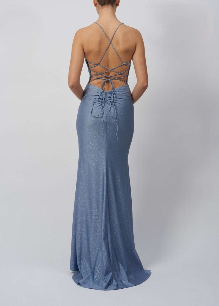 Back view of Mascara Airforce Rouched Tie Back Dress MC29335 showing crisscross tie back detail, ruched design, and shimmering fabric in light blue.