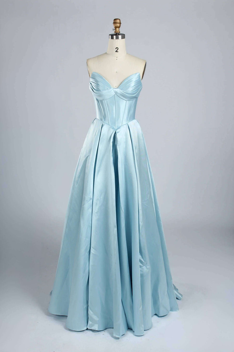 Phoebe Prom Gown in light blue satin with strapless sweetheart neckline and ruched bustier, displayed on mannequin front view.
