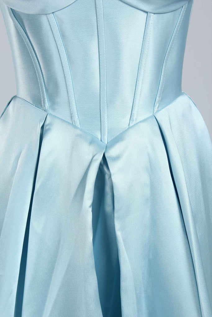 Close-up of pleated satin skirt on the Phoebe Prom Gown in light blue, emphasizing luxurious fabric and structured silhouette.