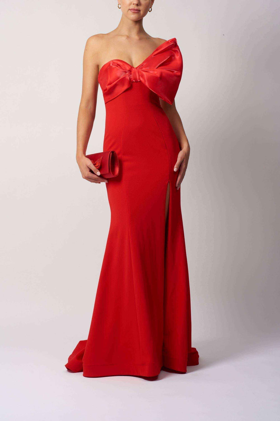 The Bow Jersey Dress - Mascara MC111441 in bold red, featuring a strapless neckline and oversized satin bow, ideal for prom or red carpet events.
