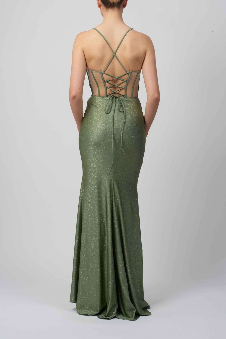 Back view of green lace-up corset prom dress with glitter finish and strappy open back. Slim-fitted gown perfect for red-carpet occasions.