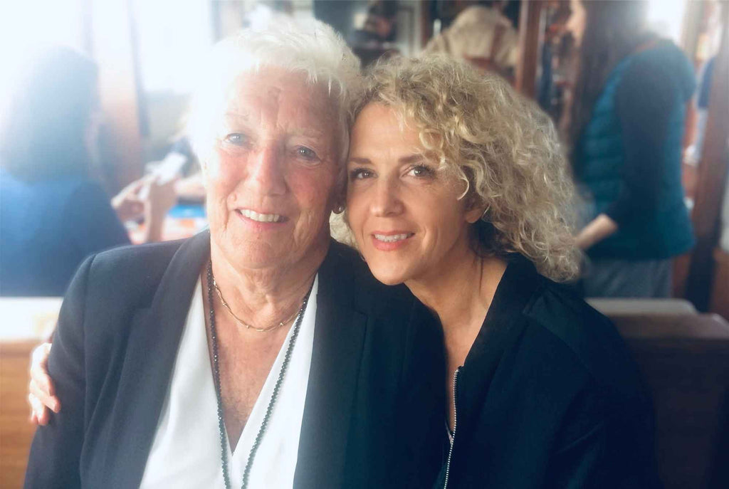 two woman sat close to each other one older lady and one younger