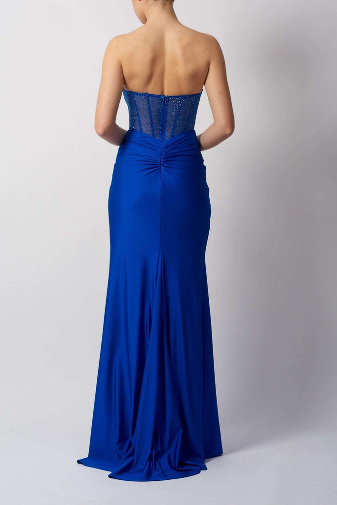 Back view of royal blue strapless gown by Mascara London, featuring ruched detailing and flowing skirt for elegant formalwear appeal.
