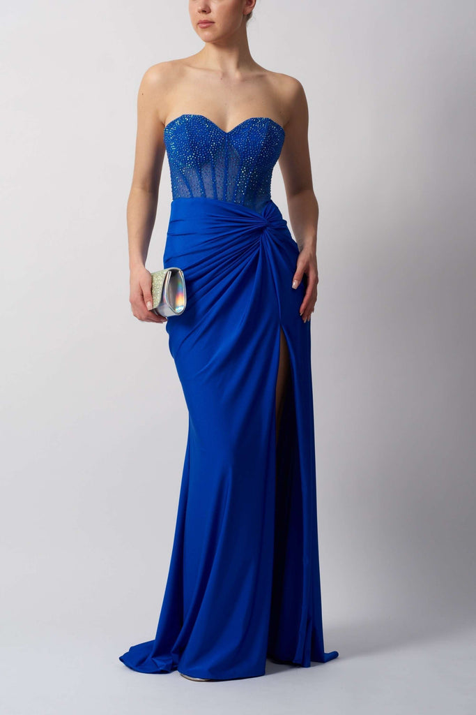 Chic strapless gown in royal blue with beaded bodice and thigh-high slit, perfect for prom or red carpet events. Enhances silhouette with ruched waist.