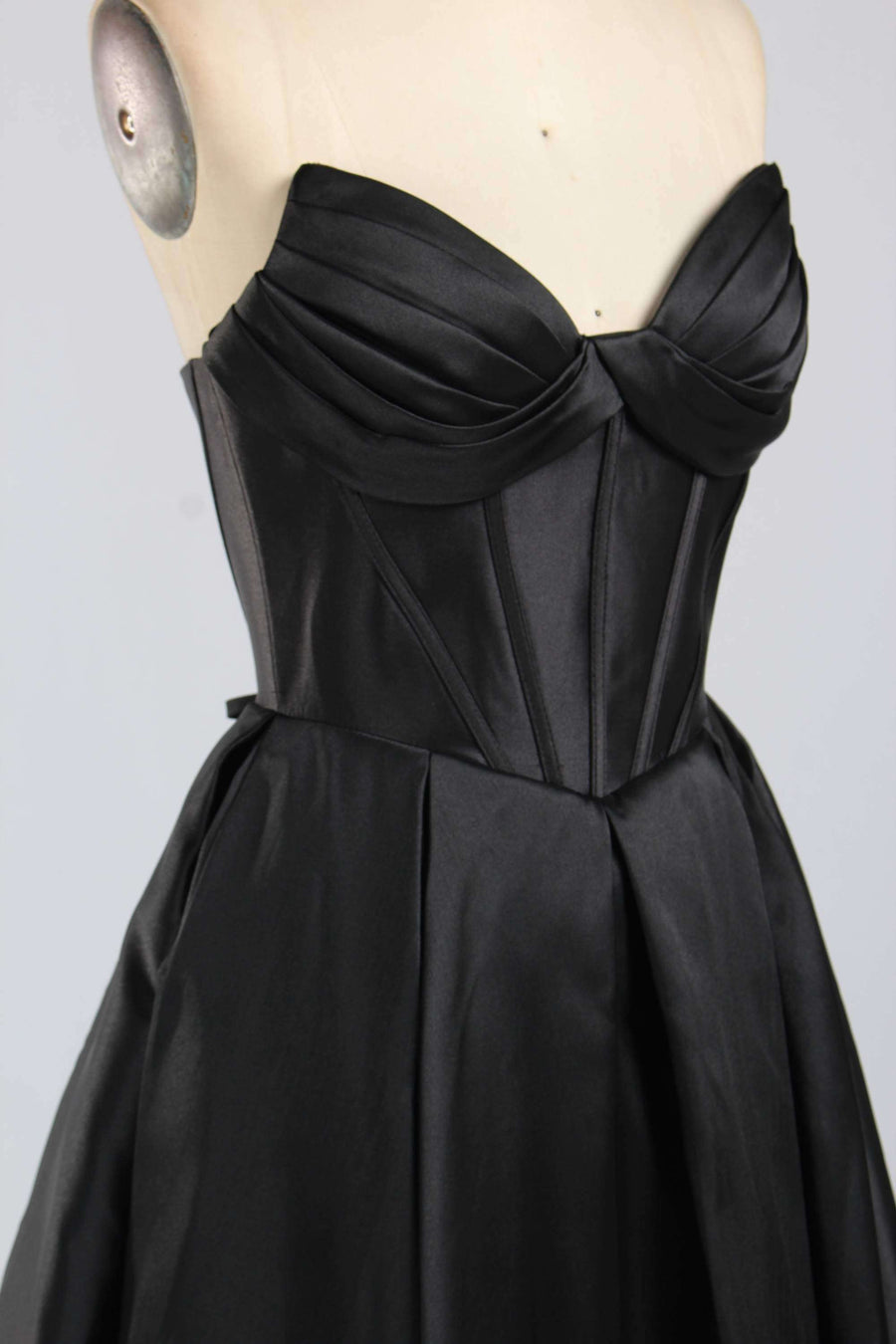 Close-up of Jessica Stuart 33313B black satin prom gown showing structured bodice with ruched detailing and sweetheart neckline.
