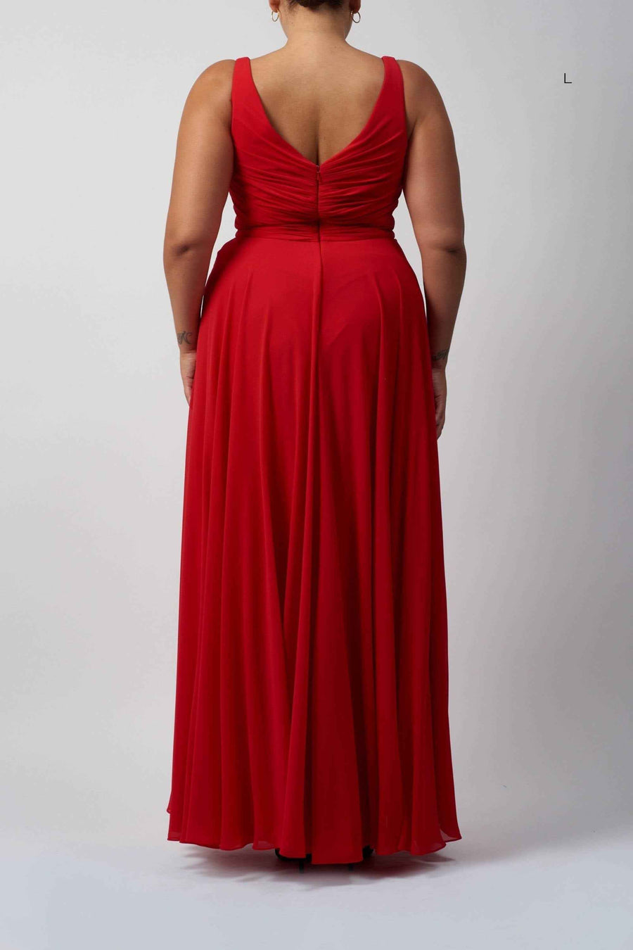 Back view of red chiffon knot front dress in plus size, showcasing ruched detailing and flowing full-length skirt.