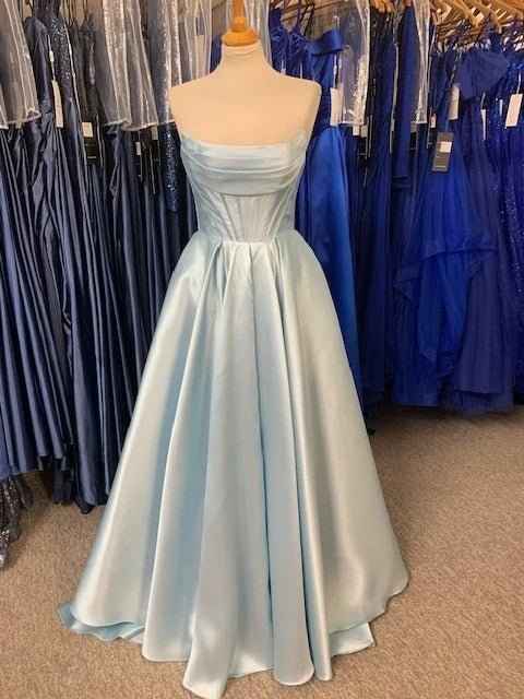 Carmen Ball Gown in light blue satin with strapless neckline, pleated skirt, and hidden pockets, displayed among other formal dresses.