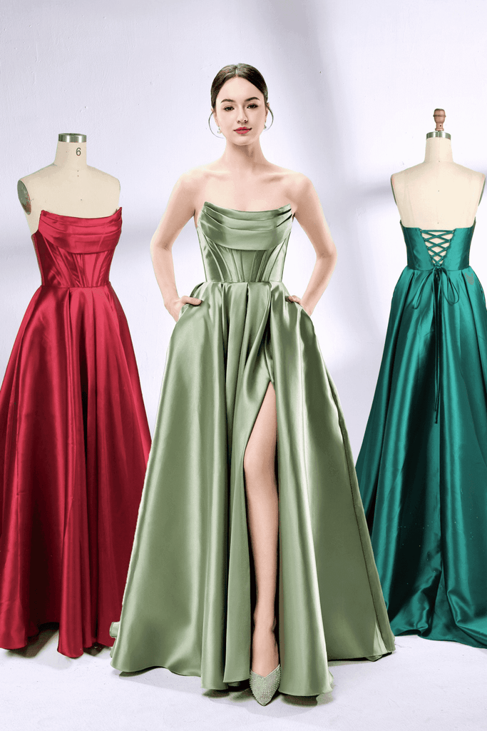 Carmen Ball Gown - Wine Red Satin with Pockets displayed on mannequin, featuring strapless bodice and pleated skirt for prom or formal events.