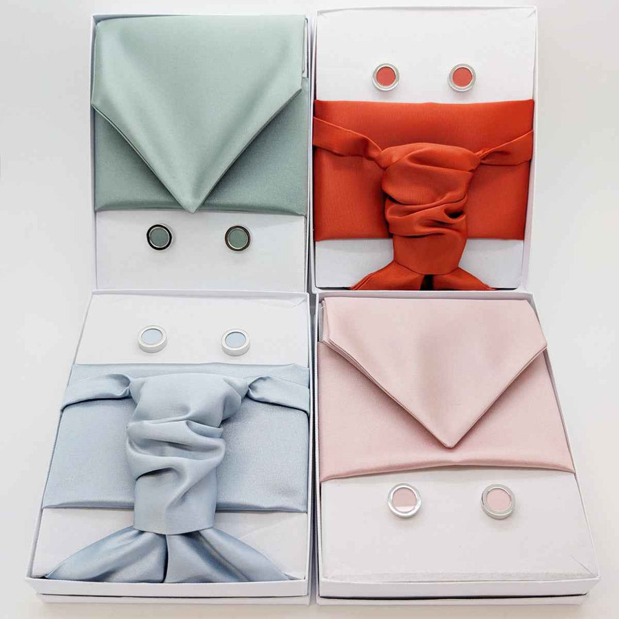 Boxed set of handmade wedding cravats in multiple colors including champagne, with matching pocket squares and cufflinks. Ideal groom accessories.
