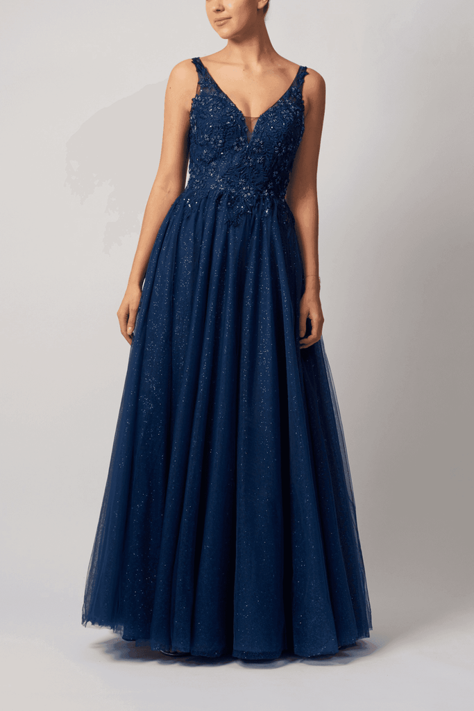 Navy V-Neck Tulle Ballgown by Mascara London featuring a glittery full-length skirt and floral embellishments. Ideal for prom or evening events.