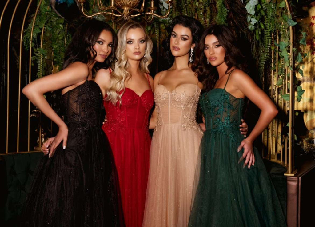 Group of models wearing Lulu corset prom dresses in black, red, nude, and green tulle with full skirts and floral detailing for 2025 prom season.