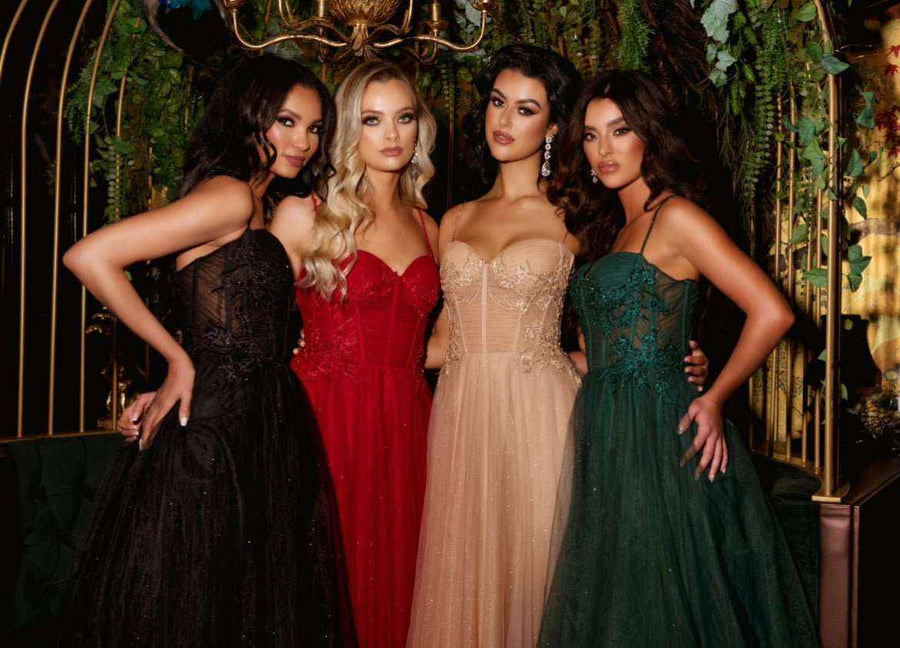 Group of models wearing Lulu corset prom dresses in black, red, nude, and green tulle with full skirts and floral detailing for 2026 prom season.