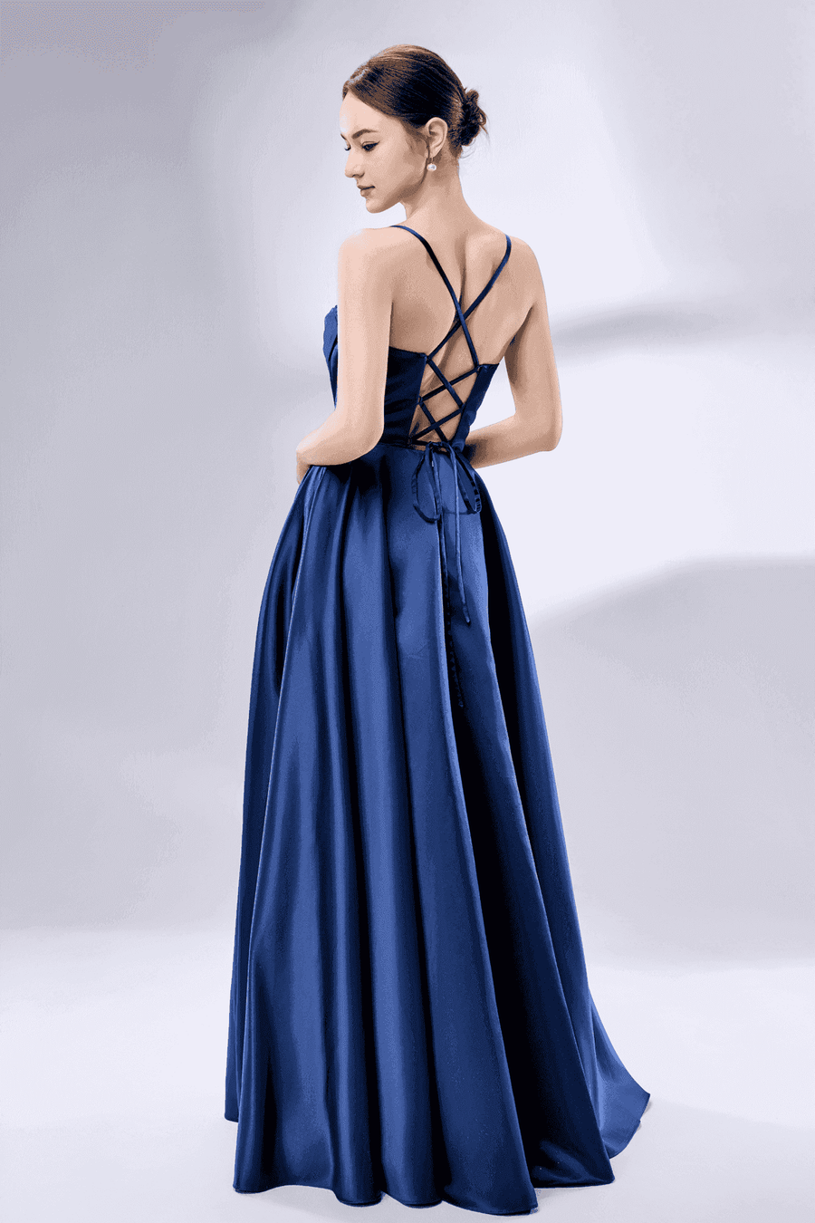 Rear view of navy blue Keira satin ballgown with crisscross lace-up back and flowing full-length skirt for formal events.