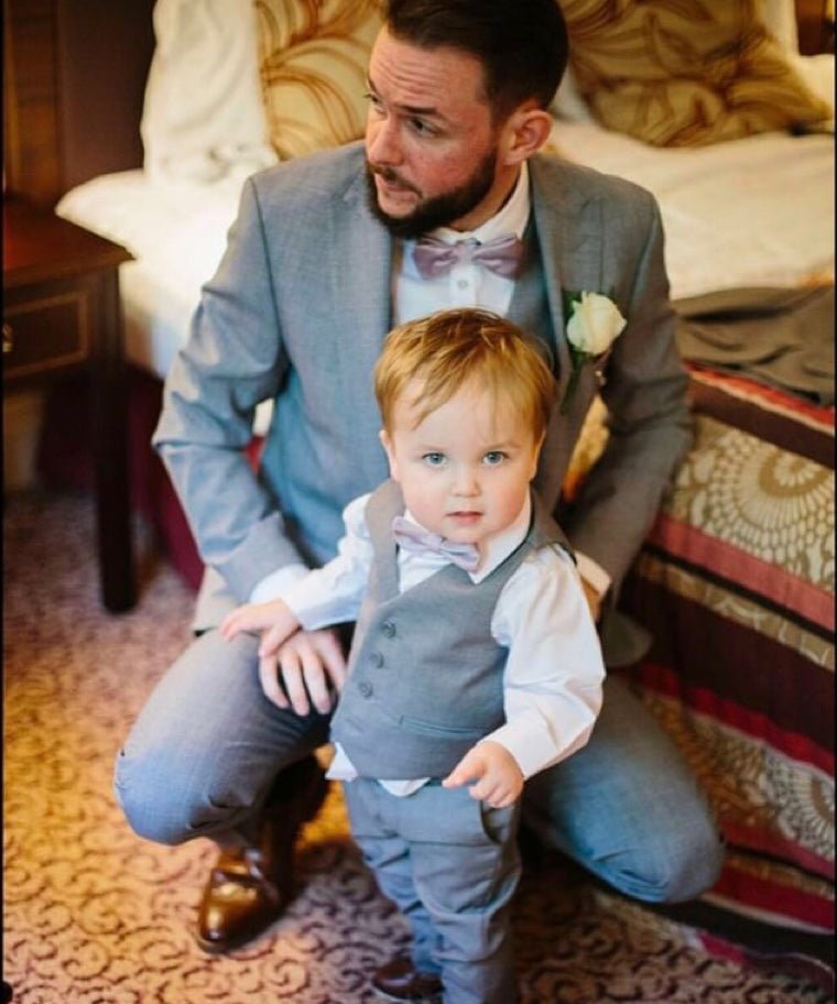 Father and son wearing matching Lavender Frost Bow Ties with grey suits at a wedding. Stylish coordinated wedding attire for men and boys.