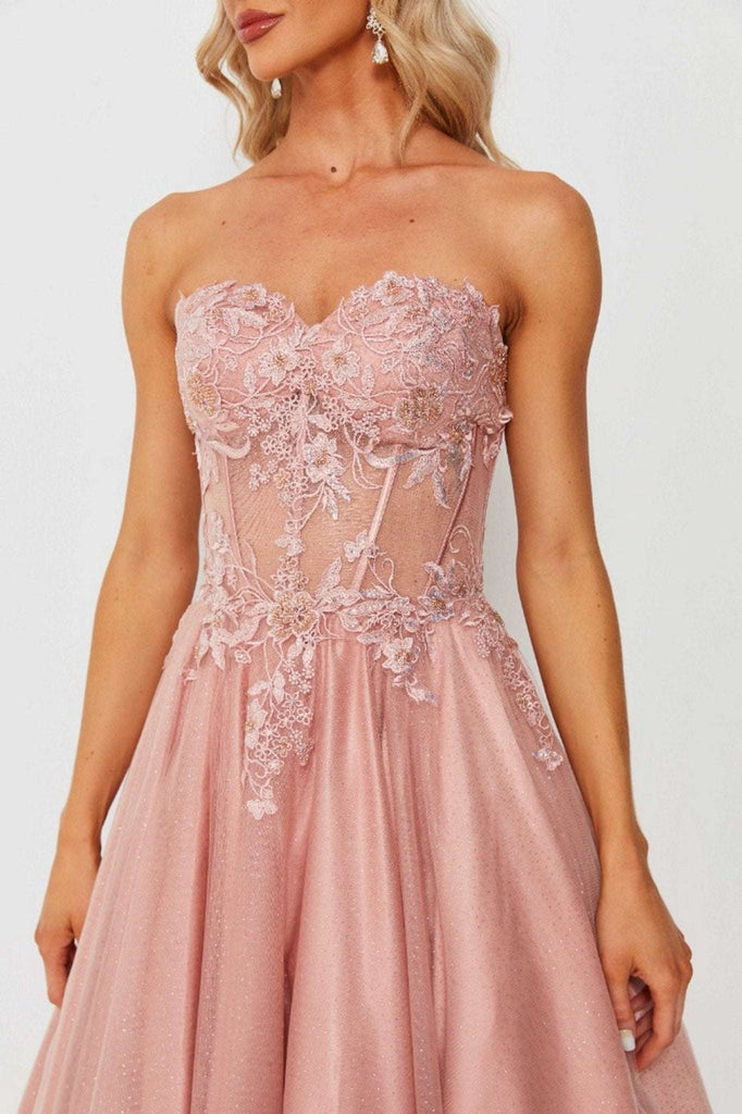 Strapless pink corset ballgown with floral lace appliqué and sheer bodice, similar to Leah Corset Ballgown style. Glamorous prom or evening dress option.