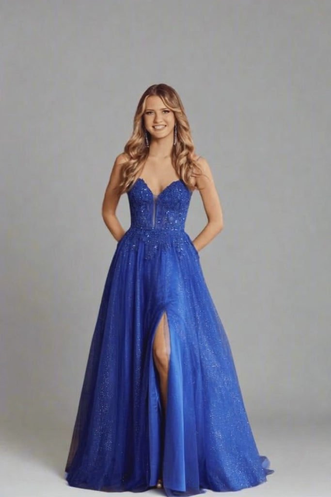 Nina Royal Blue Prom Gown by Jessica Stuart featuring a beaded bodice, V-neckline, and tulle skirt with side slit. Ideal for prom or gala events.