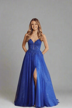 Nina Royal Blue Prom Gown by Jessica Stuart featuring a beaded bodice, V-neckline, and tulle skirt with side slit. Ideal for prom or gala events.