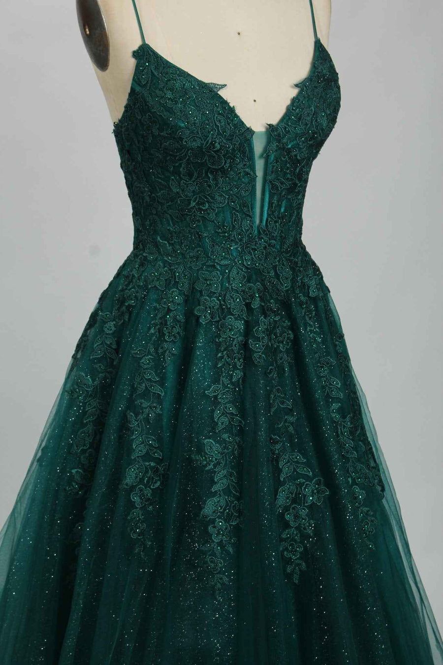 Joy Tulle Ballgown in deep green with floral applique and glitter tulle, ideal for prom or black-tie events. Features a plunging neckline and fitted bodice.
